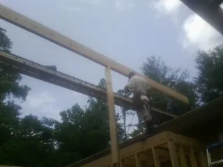 Carpenter setting a ridge beam over a new addition frame — Ice Dam Removal by Roofing Brothers in New Knoxville