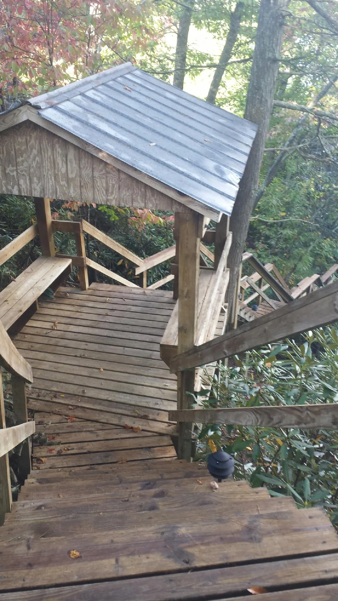 Metal roofed shelter over wooden steps on a wooded walkway — Skylight Repair & Installation work by our crew in New Knoxville