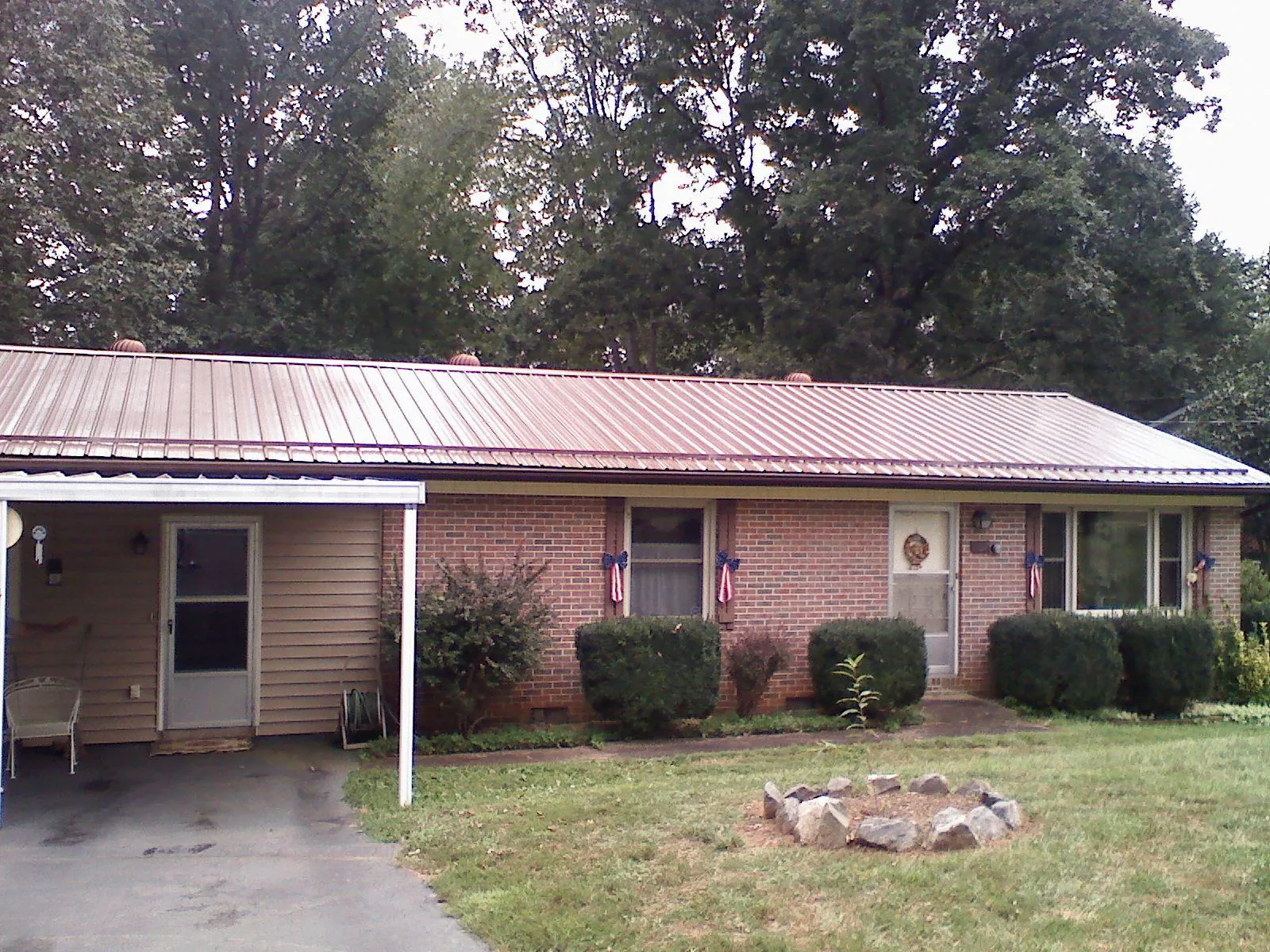 Bronze metal roof and carport on a brick ranch home — Roof Repair work by our crew in New Knoxville